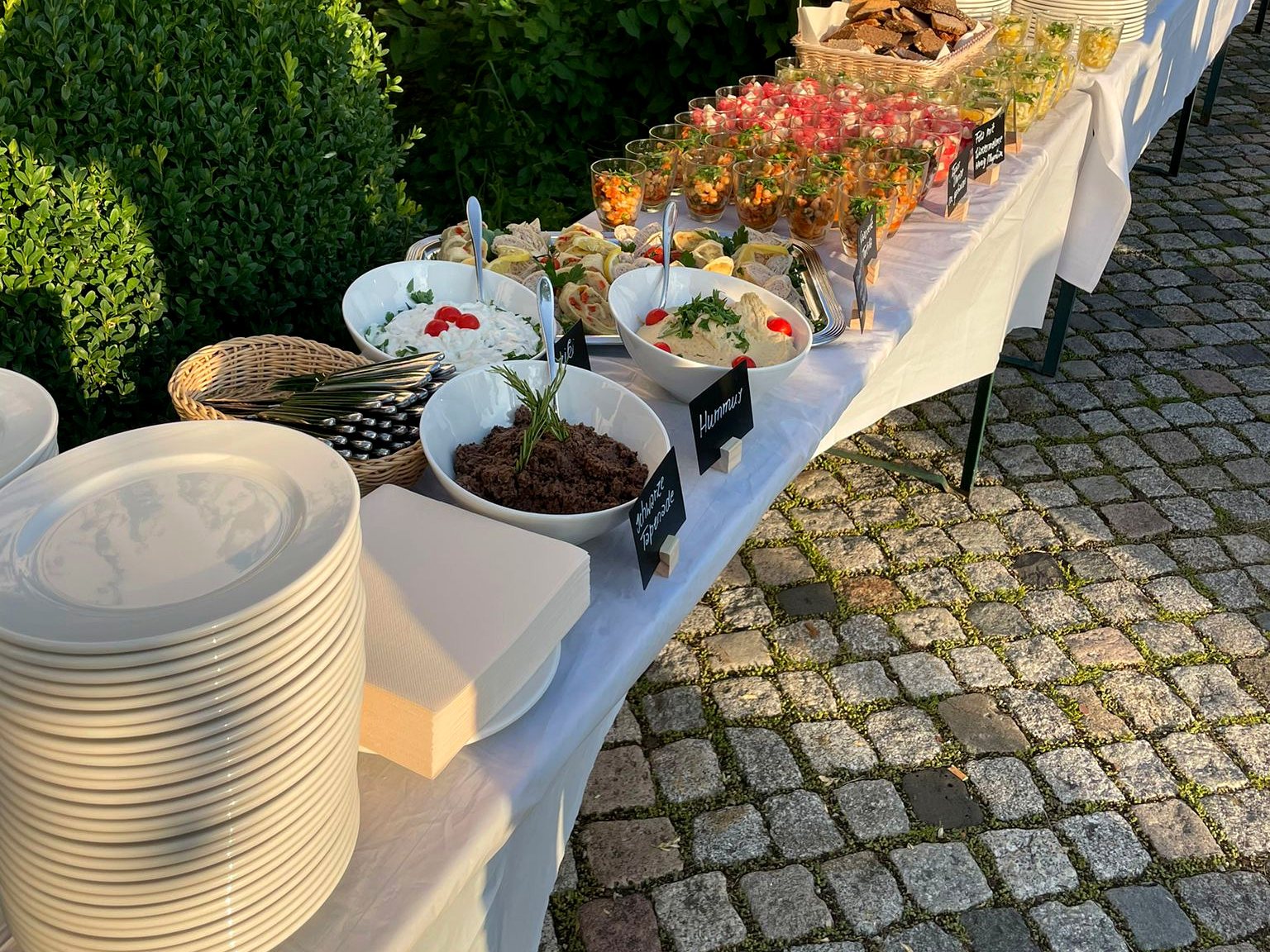 Langes Buffet im Freien auf Kopfsteinpflaster im Abendlicht