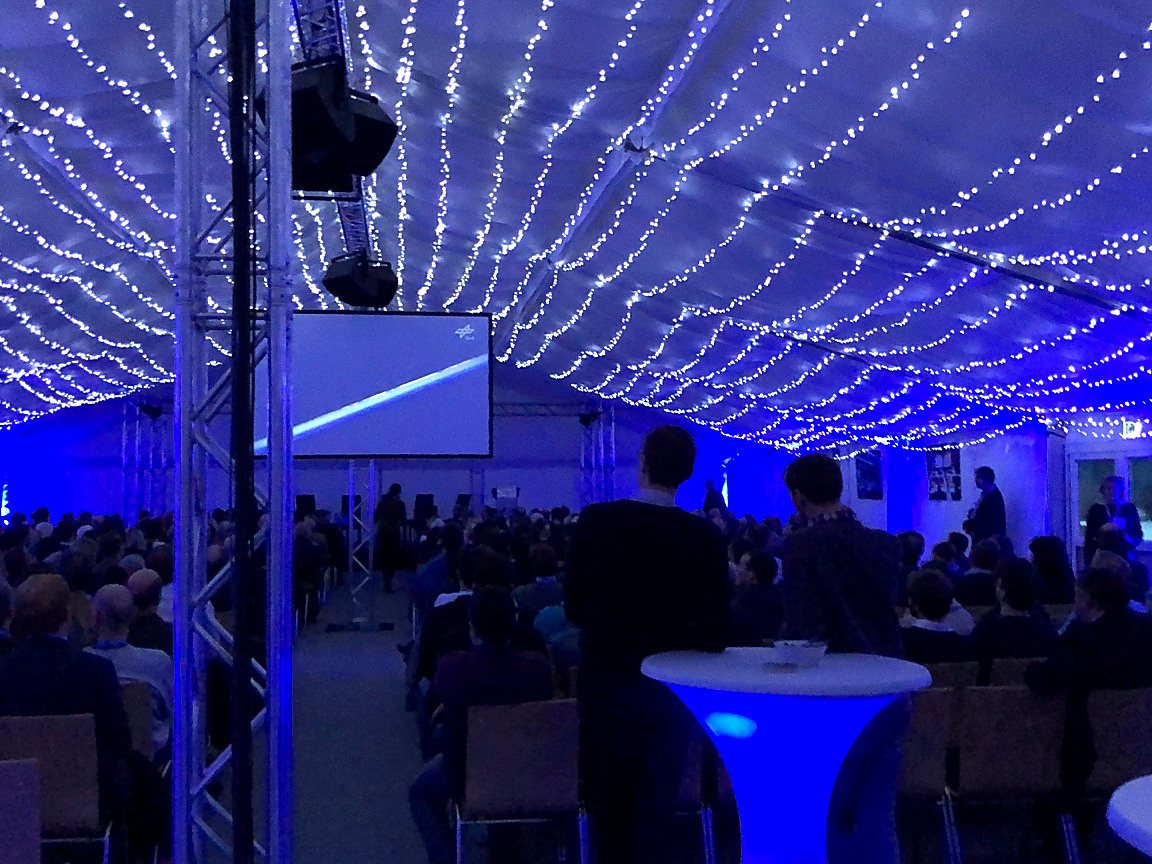 Eventzelt mit Lichterketten und Publikum vor der Leinwand